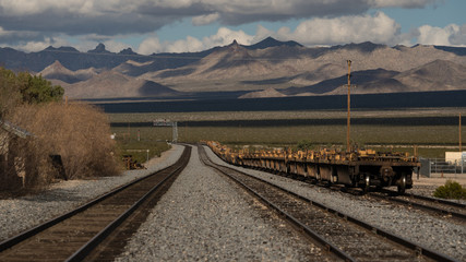 Fototapeta premium long railroad tracks and machinery on tracks in the Mojave desert near Kelso. 