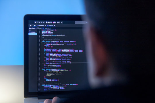 Programmer working on laptop computer in office