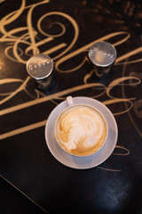 Cup of coffee with salt and pepper shaker on table in coffee shop cafe