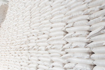 Theme industry and economics, stocks in stock.A lot of white fabric bags close-up with loose products stacked in piles indoors at the production. Angar for storing the finished product in the package.