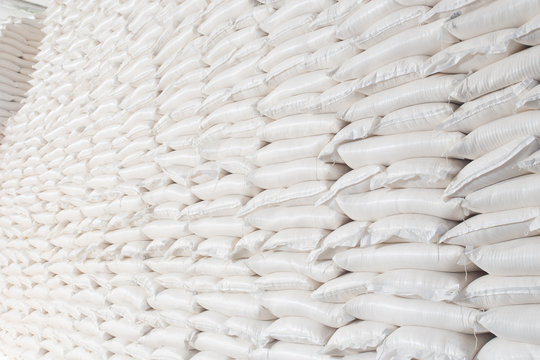 Theme industry and economics, stocks in stock.A lot of white fabric bags close-up with loose products stacked in piles indoors at the production. Angar for storing the finished product in the package.