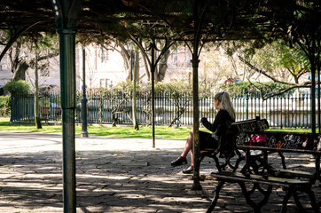 Obraz premium A young woman sitting at a bench in park