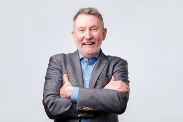 Senior man in suit and glasses laughing