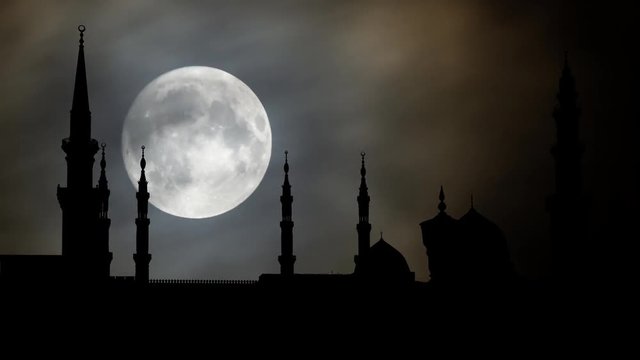 Masjid Al Nabawi or Nabawi Mosque (Mosque of the Prophet) by Night with big Full Moon and Clouds in Time Lapse, Medina (City of Lights), Saudi Arabia