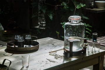 Glass jar with water and a glass of water placed in Ruen Thai,