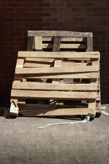 Large Broken Timber Pallets Leaning Against Brick Wall
