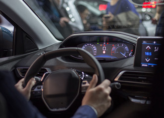 Hands of steering wheel of car