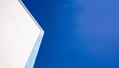Fototapeta na wymiar Greece. White building with blue details closeup view, blue sky background, copy space