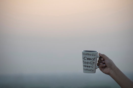 Coffee Mug in hand in plain background