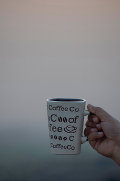 Coffee Mug in hand in plain background
