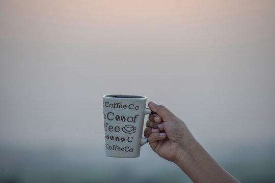 Coffee Mug in hand in plain background