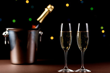 glasses of champagne on black  background with bokeh circles. Place for text.