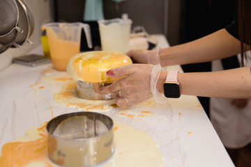 Mousse yogurt cake. Girls cook and creat a drawing of mousse on the cake. Frozen mirror icing on the cake. Culinary masterpieces