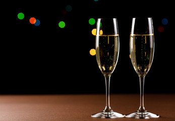 glasses of champagne on black  background with bokeh circles. Place for text.