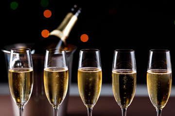 glasses of champagne on black  background with bokeh circles. Place for text.