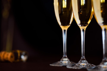 glasses of champagne on black  background with bokeh circles. Place for text.