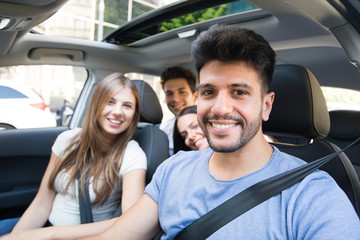 Group of happy friends sharing the same car for a trip