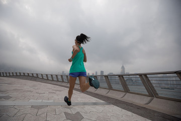 Healthy lifestyle woman runner running on foggy city morning