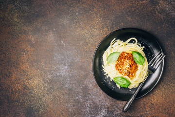 tagliatelle pasta with bolognese sauce and parmesan cheese in black plate