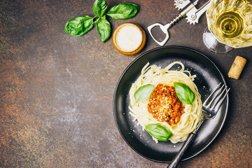 tagliatelle pasta with bolognese sauce and parmesan cheese in black plate