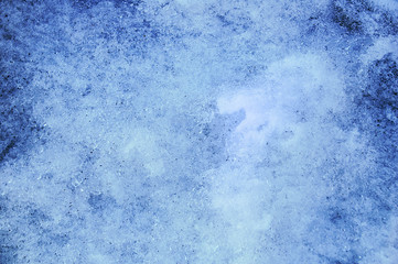 The texture of melting snow and ice. Close-up. Blue tone.