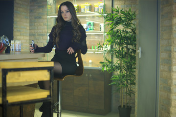 Vaping teenager. Young pretty white girl smoking an electronic cigarette in vape bar. Bad habit.