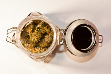 Marijuana buds in open mason jar on white background
