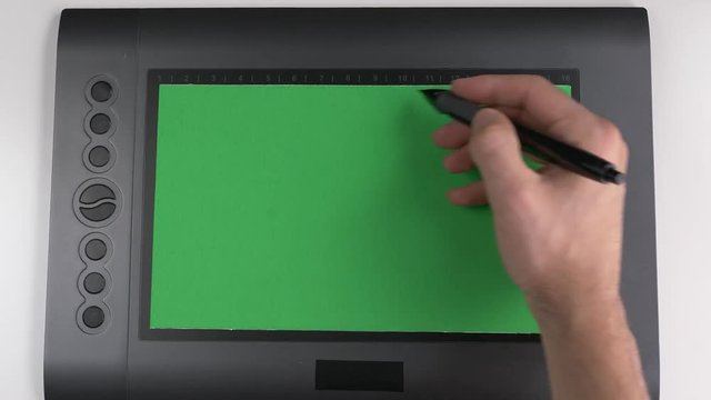 Top view of a designer drawing tablet being used with a green screen drawing surface.