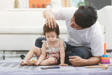 VIew of a Father and his little daughter using mobile at home .