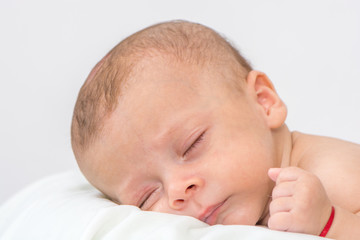 picture of a newborn baby curled up sleeping on a blanket