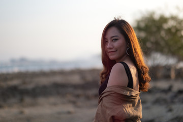 Fototapeta premium A beautiful asian woman walking on the beach by the seashore