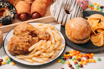 fast food and unhealthy eating concept - close up of fast food snacks and cola drink on white table