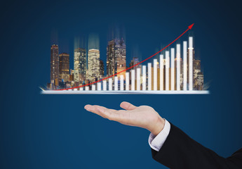 Real estate business investment concept. Businessman hand holding digital tablet with buildings...