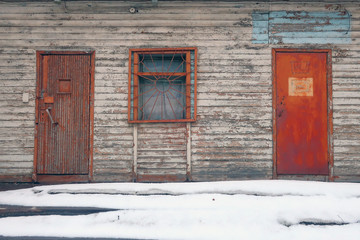 porch of an old house with rusty doors and bars on the window