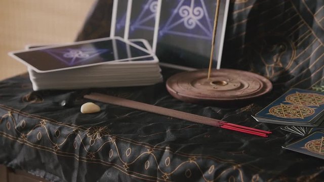 Placing chakra crystals on a table with tarot cards and incense