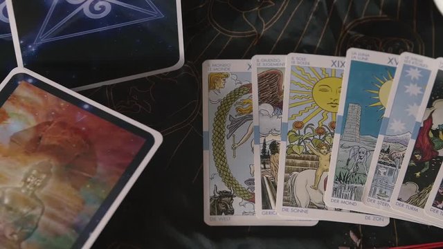 Slow pan across tarot cards on black cloth