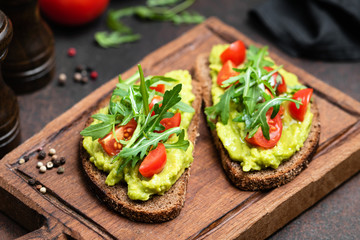 Vegan or Vegetarian Toast with mashed avocado, arugula served on wooden board