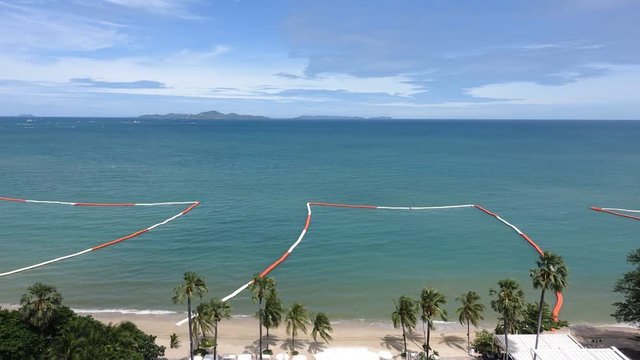 Time-Lapse dividers of orange and white section off an ​area of beach for safe swimming.