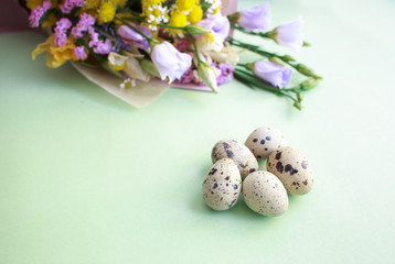 Quail eggs and a bouquet of spring flowers