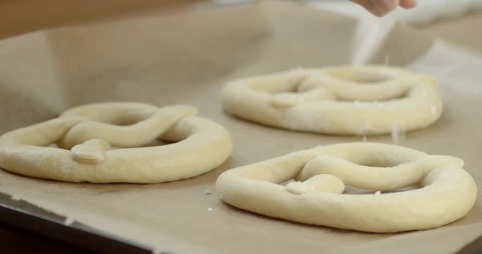 Slowmotion shot of salt being put on frozen Pretzels.