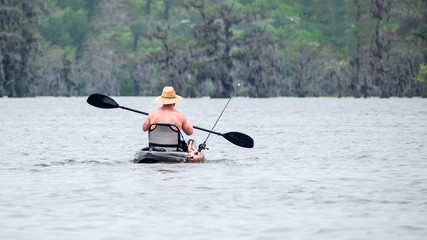 Fototapeta na wymiar People are enjoying canoing, boating and fishing in swamp