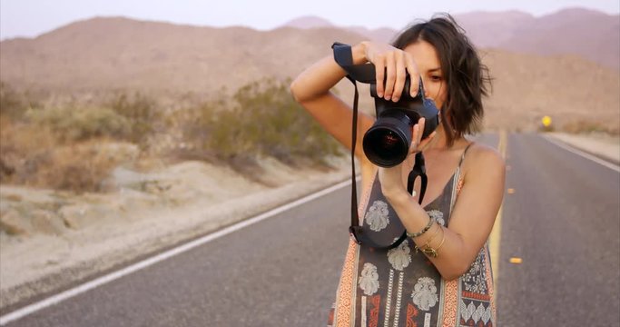 Female photographer reviewing photos on DSLR close up - in desert landscape
