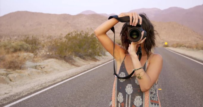 Female photographer taking photo on DSLR close up - in desert landscape
