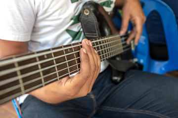 Close-up fingers and bass guitar.