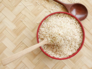 organic rice on bamboo floor .raw rice in bowl or in spoon on bamboo floor .topview,copy space.