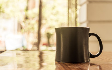 Closeup image of a cup of Cappuccino, mocha, latte, Americana, espresso hot coffee aroma for on rustic wooden table background in cafe with backdrop of sunlight light coming from window in morning.