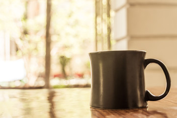 Closeup image of a cup of Cappuccino, mocha, latte, Americana, espresso hot coffee aroma for on rustic wooden table background in cafe with backdrop of sunlight light coming from window in morning.