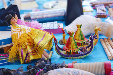 Fototapeta premium Doll with typical aymara clothes and two toy boats like from island Uros.