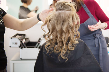 Hairdressing services. Сreating  hairstyle. Hair styling process. Children's hairdressing salon.