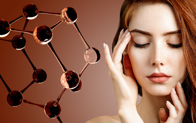 Beautiful redehead woman near big white molecule structure.